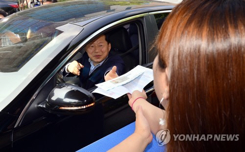 심보균 행정안전부 차관이 8일 광주 광산구 첨단2동 주민센터에서 주민 맞춤형 행정혁신으로 민원처리 시간을 단축하는 ‘차타Go 민원보Go 센터’ 현장을 방문해 ‘드라이브 스루’ 방식의 민원서비스를 체험하고 있다./연합뉴스