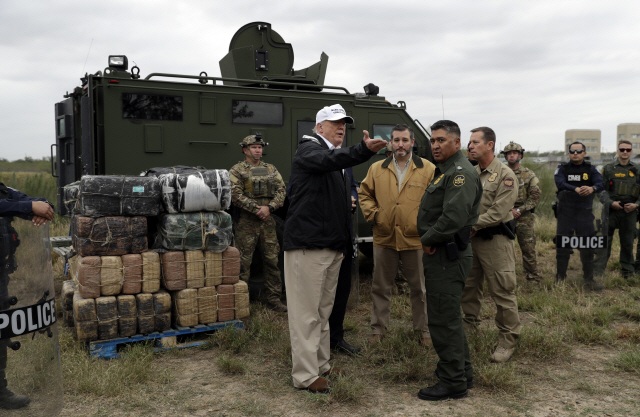 10일(현지시간) 미국 텍사스주 리오 그란데의 멕시코 접경을 방문한 도널드 트럼프 대통령(가운데)이 현지 국경경비 관계자들에게 얘기하고 있다. /AP=연합뉴스