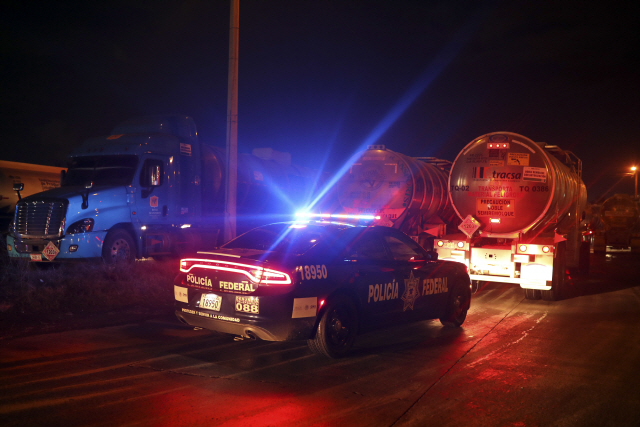 석유 부족사태 속에 9일(현지시간) 멕시코 베라크루스에서 국영 석유기업 페멕스의 저유소를 나서는 석유 탱커 트럭을 경찰차가 호송하고 있다. /베라크루스=AP연합뉴스