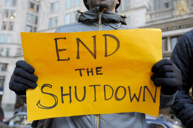 11일(현지시간) 한 시민 미국 보스톤에 위치한 환경보호청(EPA) 앞에서 ‘셧다운을 끝내라’라고 적힌 피켓을 들고 시위를 하고 있다. /보스톤=EPA연합뉴스