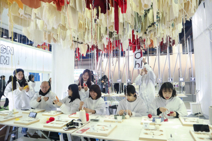 지난해 12월 열린 서울디자인페스티벌에서 업사이클링 워크숍 리테이블에서 참가자들이 안 입는 스웨터를 크리스마스 트리 장식으로 만들고 있다.    /사진제공=코오롱FnC