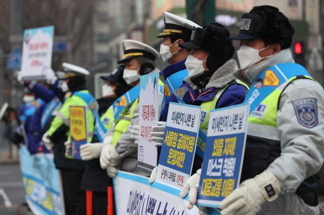 14일 서울 광화문 사거리에서는 마스크를 쓴 경찰들이 미세먼지 줄이기 시민참여 캠페인을 벌였다.  /연합뉴스