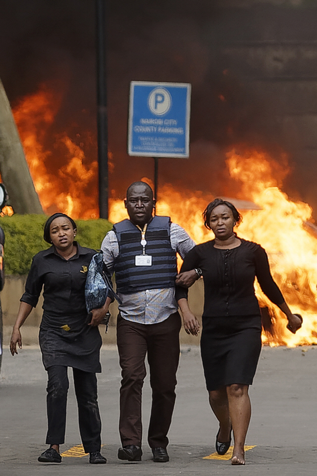 케냐 수도 나이로비 도심에서 15일(현지시간) 총격과 폭탄 테러가 발생한 직후 경찰이 시민들을 피신시키고 있다. 외신은 이날 나이로비 ‘리버사이드 드라이브’ 지역의 상업단지 인근에서 폭탄이 최소 한차례 폭발했고 격렬한 총격 소리도 들렸다며 최소 2명이 숨졌다고 전했다./AP연합뉴스