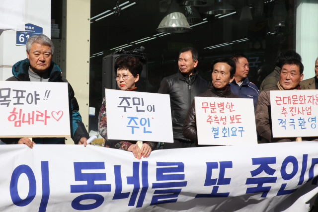 21일 전남 목포시 만호동 거리에서 열린 기자회견에서 주민들이 차질없는 도시재생사업 시행을 촉구하고 있다. /목포=연합뉴스