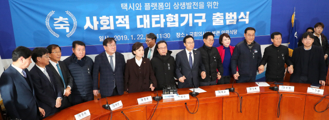 22일 오전 국회에서 열린 택시와 플랫폼의 상생발전을 위한 사회적 대타협기구 출범식에서 더불어민주당 홍영표 원내대표(오른쪽 여섯번째), 김현미 국토부 장관, 정주환 카카오모빌리티 대표, 택시 4개 단체장 등이 기념촬영을 위해 자리를 잡고 있다. /연합뉴스