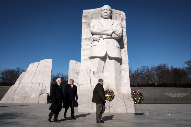 도널드 트럼프(가운데) 미국 대통령이 21일(현지시간) 흑인 인권운동가 마틴 루서 킹 목사 기념 공휴일을 맞아 마이크 펜스(왼쪽) 부통령과 워싱턴DC 내셔널몰에 있는 킹 목사 기념비를 방문하고 있다. 트럼프 대통령은 이날 예고 없이 기념비를 방문해 약 2분 만에 떠났다고 외신들은 전했다.         /워싱턴DC=EPA연합뉴스