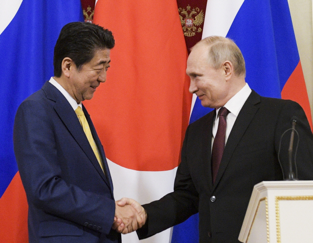 러시아를 방문한 아베 신조(왼쪽) 일본 총리가 22일(현지시간) 크렘린궁에서 블라디미르 푸틴 러시아 대통령과 악수를 나누고 있다. /모스크바=AP연합뉴스