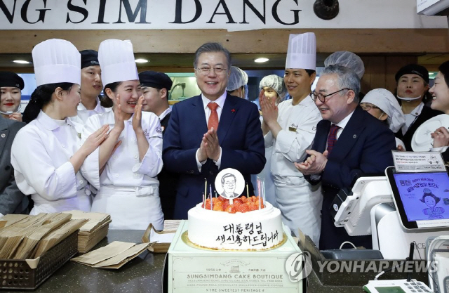 문재인 대통령이 24일 오후 전국경제투어로 대전을 방문, 대전의 명물 성심당 빵집에서 튀김 소보로를 구매한 후 직원들로부터 깜짝 생일축하 케이크를 받고 있다.