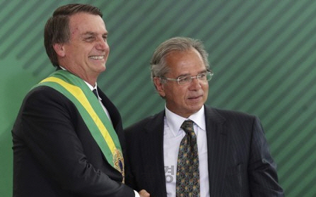 자이르 보우소나루 브라질 대통령으로 부터 임명장을 받고 악수를 하고 있는 파울루 게지스(왼쪽) 브라질 신임 경제장관  /AP연합뉴스