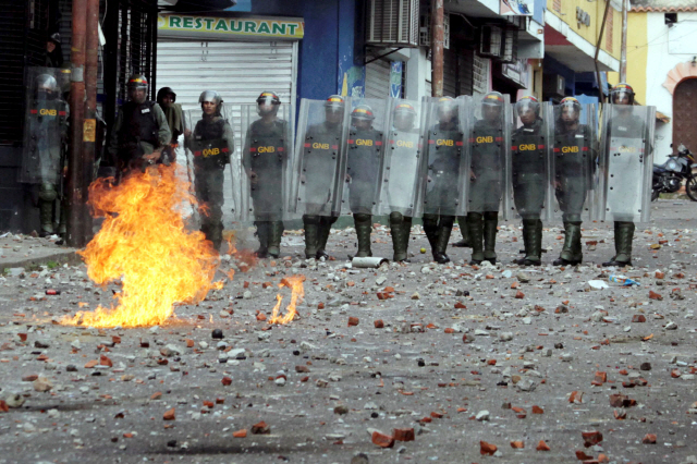 베네수엘라의 타치라에서 23일(현지시간) 경찰이  니콜라스 마두로 정권에 반대하며 화염병을 던지는 시위대와 대치하고 있다. 이번 시위로 현재까지 26명이 사망했다./타치라=로이터연합뉴스