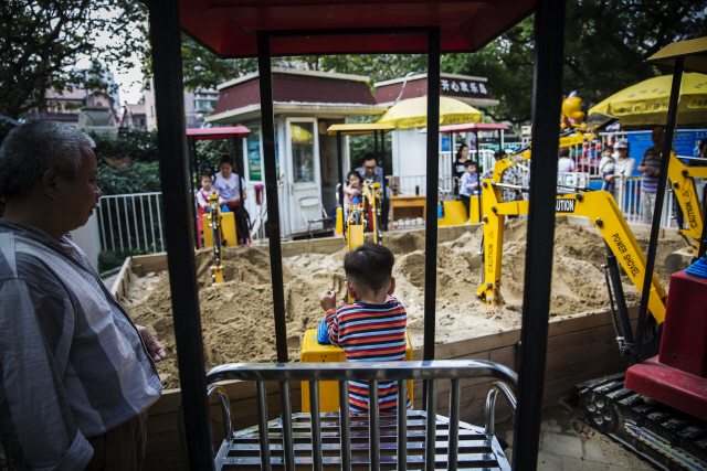 조부모와 부모들이 중국 상하이의  놀이시설에서 노는 아이들을 지켜보고 있다.  /블룸버그통신