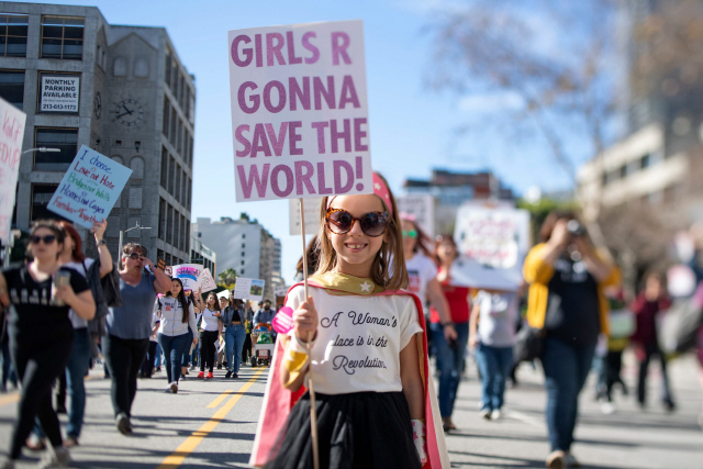 19일(현지시간) 올해 세번째로 열린 ‘여성행진(Women’s March)‘ 시위에 참석한 한 소녀가 로스엔젤러스(LA)에서 “여성들이 세상을 구할 것이다”라는 피켓을 들고 거리를 행진하고 있다./LA=AFP연합뉴스