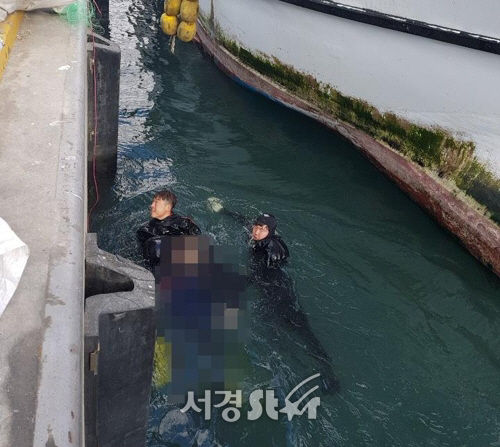 26일 오후 제주 한림항 어선부두에서 해경 구조요원들이 물에 빠진 선원 윤모(66)씨를 구조하고 있다. 윤씨는 병원으로 옮겨졌으나 결국 숨졌다./제주해양경찰서 제공