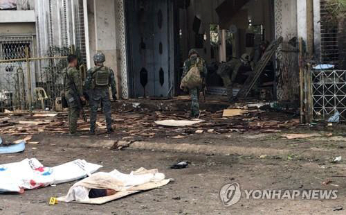 필리핀 군인들이 27일(현지시간) 폭발로 크게 부서진 성당 중앙 출입구 부근을 조사하고 있다./연합뉴스