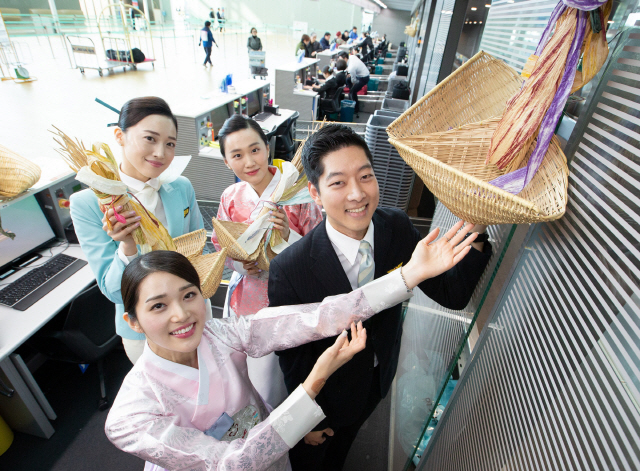 대한항공 객실승무원들과 승객들이 인천공항 제2 여객터미널 대한항공 카운터에서 새해를 맞아 고객들의 행운과 안전을 기원하는 복조리를 걸고 기념촬영을 하고 있다. 대한항공은 황금 돼지의 해를 맞아 28일부터 2월 10일까지 국내 사업장에 복조리를 거는 행사를 진행한다./사진제공=대한항공