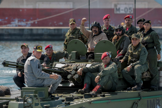 Handout picture released by the Venezuelan presidency showing Venezuela‘s President Nicolas Maduro (C), his wife Cilia Flores (R at centre) and commanders disembarking in an amphibious vehicle during military exercises at the Naval Base Agustin Armario in Puerto Cabello, Carabobo State, Venezuela, on January 27, 2019. - Maduro on Sunday rejected a European ultimatum that he call elections as opposition rival Juan Guaido stepped up appeals to the military to turn against the leftist government. (Photo by HO / Venezuelan Presidency / AFP) / RESTRICTED TO EDITORIAL USE - MANDATORY CREDIT “AFP PHOTO / VENEZUELAN PRESIDENCY” - NO MARKETING NO ADVERTISING CAMPAIGNS - DISTRIBUTED AS A SERVICE TO CLIENTS      <저작권자(c) 연합뉴스, 무단 전재-재배포 금지>