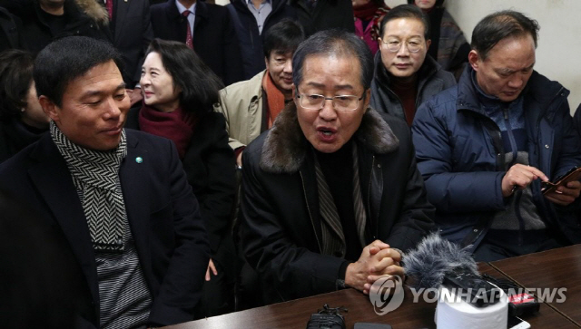 자유한국당 홍준표 전 대표가 26일 오후 부산 중구 자갈치시장을 방문해 취재진 질문에 답하고 있다./연합뉴스