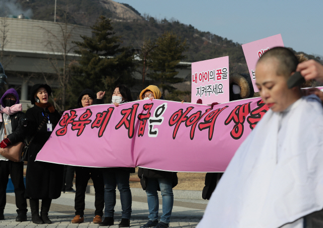 새해 첫날인 지난 1일 서울 청와대 앞에서 ‘양육비 해결모임’의 강민서 부대표가 양육비 지급 제도 개선을 촉구하며 삭발하고 있다./연합뉴스