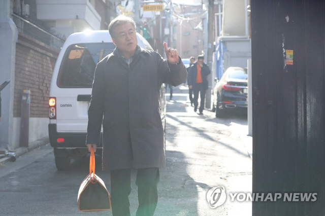 문재인 대통령이 1일 오전 서울 관악구 주택가에서 취약계층 청소년 가정에 도시락 배달 봉사를 하고 있다./연합뉴스