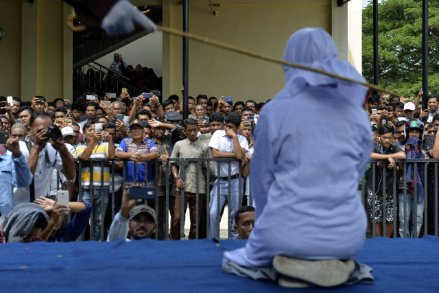 인도네시아의 10대 커플이 지난달 31일 아체주 반다아체의 이슬람사원 밖에서 태형을 받고 있다. /AFP연합뉴스