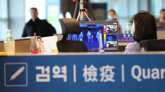 지난달 29일 인천공항에서 입국객들이 체온을 측정하기 위한 열화상카메라 앞을 지나고 있다. /연합뉴스