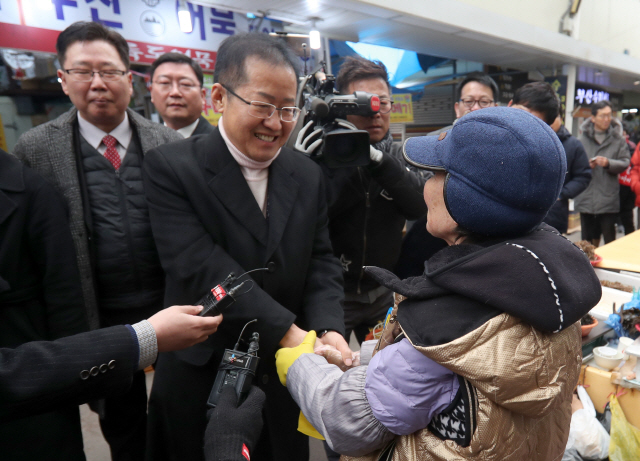 자유한국당 홍준표 전 대표가 8일 오후 경남 창원시 마산합포구 마산어시장을 찾아 상인과 인사하고 있다./연합뉴스