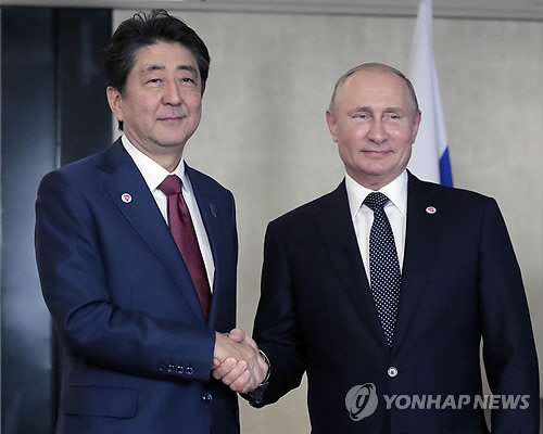 아베 신조 일본 총리(왼쪽)와 블라디미르 푸틴 러시아 대통령이 작년 11월 싱가포르에서 만나 악수를 나누는 모습 /EPA=연합뉴스
