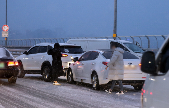 눈이 내린 15일 오전 출근차량이 서울 마포대교 위에 연쇄추돌 사고로 정차해 있다./ 연합뉴스