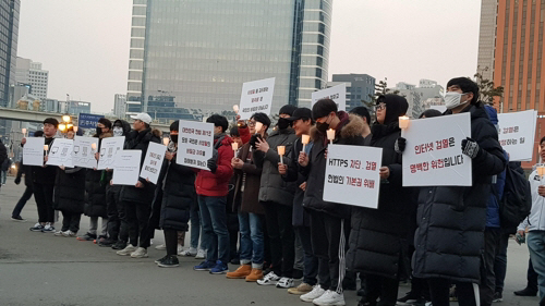 16일 서울역 광장에서 열린 ‘https 차단정책 반대시위’에서 참가자들이 피켓과 촛불을 들고 있다./연합뉴스