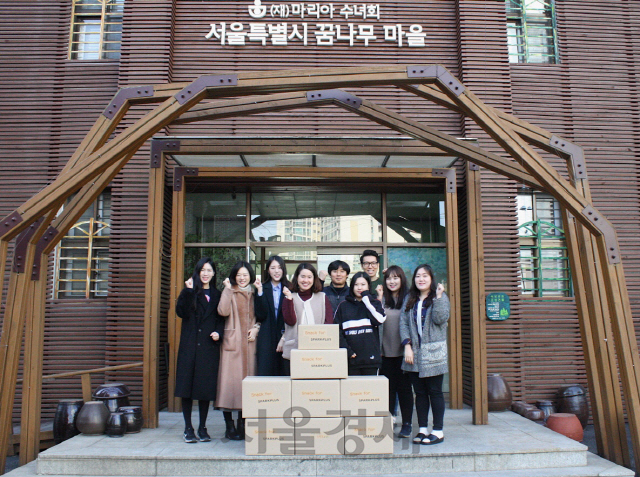 스파크플러스와 스낵포 관계자들이 지난 14일 서울 은평구 꿈나무마을 학생들에게 전달할 물품 앞에서 포즈를 취했다./사진제공=스파크플러스
