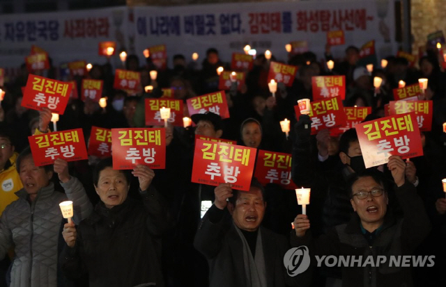 21일 오후 강원 춘천시 석사동 김진태 의원 사무실 앞에서 진보단체 회원과 시민들이 촛불집회를 열고 김 의원의 퇴진을 촉구하고 있다./연합뉴스