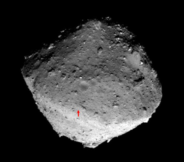 일본의 우주탐사선 ‘하야부사2’가 지난달 24일 촬영한 소행성 ‘류구’의 모습. 아래 빨간 화살표는 하야부사2의 착륙지점.    /EPA연합뉴스