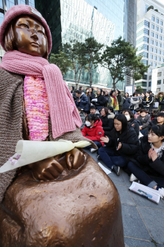 지난 2018년 11월28일 오후 서울 종로구 일본대사관 앞에서 열린 제1363차 일본군 ‘위안부’ 문제 해결을 위한 정기 수요집회에서 참가자들이 차가운 바닥에 앉아 일본의 사과를 요구하고 있다./연합뉴스