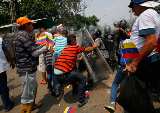 23일(현지시간) 콜롬비아와 국경을 접한 베네수엘라 우레냐의 한 국경 다리에서 원조 반입을 두고 야권 지지자들과 경찰이 몸싸움을 벌이고 있다. /우레냐=AFP연합뉴스
