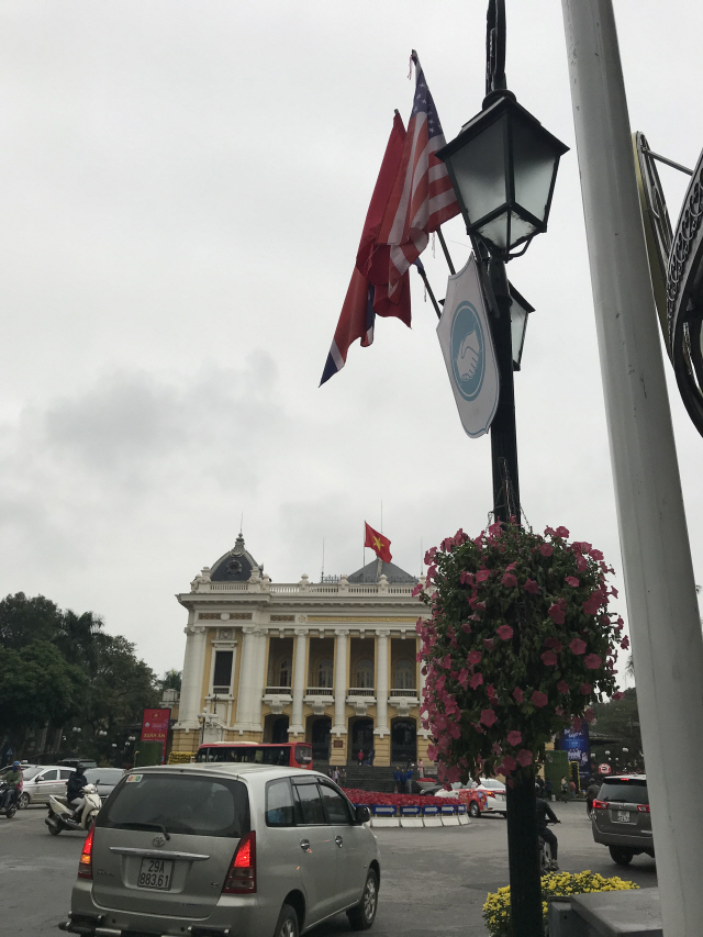 25일 베트남 하노이 오페라 하우스 도로의 모습. 가로등에 미국, 북한, 베트남 국기, 악수하는 간판과 함께 꽃 바구니가 눈에 띈다. /이태규기자