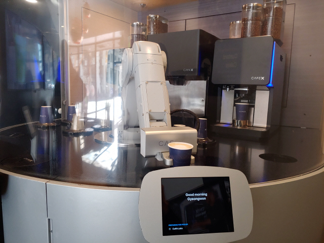 미국 샌프란시스코의 로봇 바리스타 카페 ‘카페X 마켓’ 지점에서 로봇이 카페 라테를 건네주고 있다. /샌프란시스코=권경원기자