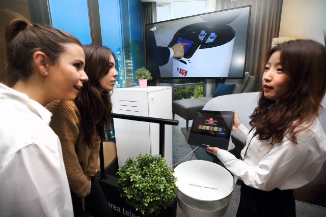 KT 직원이 25일(현지시간) 스페인 바르셀로나에서 열린 MWC 2019에서 관람객에게 5G ‘AI 호텔 로봇’을 설명하고 있다./사진제공=KT