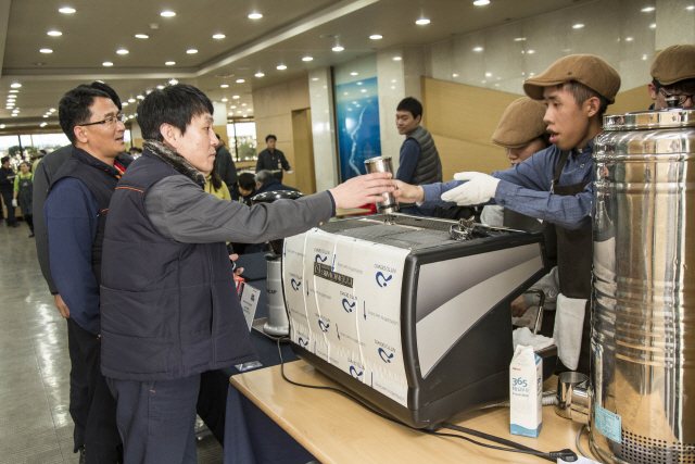 SK인천석유화학 직원들이 지난 21일 인천에서 열린 ‘1% 나눔, 100% 행복’ 커피 나눔 이벤트 현장에서 발달장애인 바리스타들에게 커피를 받고 있다. /사진제공=SK이노베이션