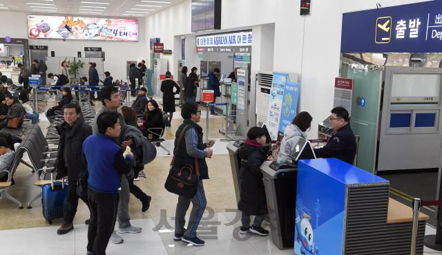 지난 25일 원주공항 이용객들이 제주행 항공기에 탑승하기 위해 게이트 앞에 줄을 서 있다.      /원주=이호재기자.