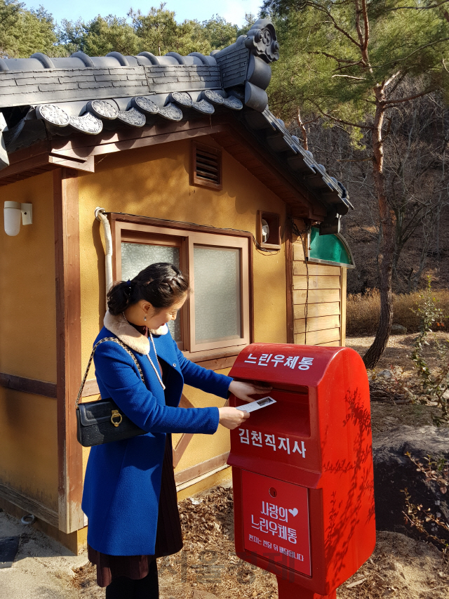 김천시가 직지사에 설치한 느린 우체통에 관광객이 우편물을 투입하고 있다.