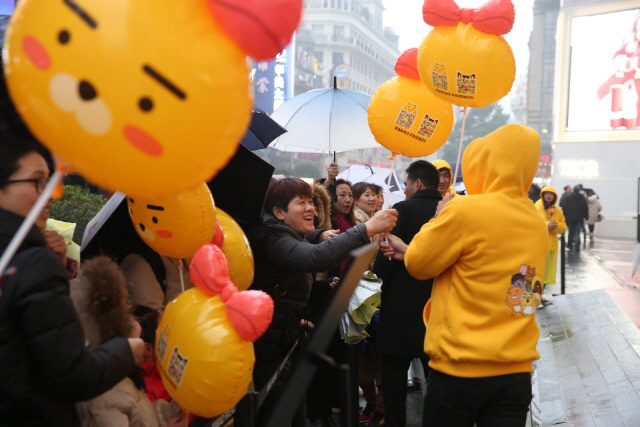 관람객들이 중국 상하이 스마오 광장에 마련된 카카오프렌즈 전시 공간에서 라이언 풍선을 받고 있다. /사진제공=카카오IX