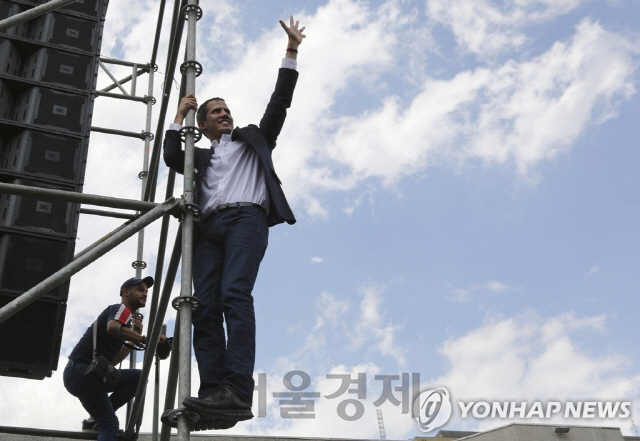 무대 구조물에 올라가 지지자들의 귀국 환영에 인사하는 후안 과이도 국회의장/연합뉴스