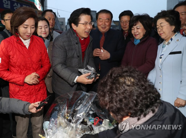 자유한국당 황교안 대표가 5일 새벽 서울 남대문시장을 방문해 시장 상인으로부터 김밥을 사고 있다./연합뉴스