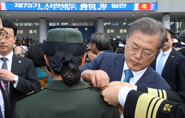 문재인 대통령이 5일 경남 창원 해군사관학교에서 열린 제73기 졸업 및 임관식에서 해병대 김보현 소위에게 계급장을 달아주고 있다. /연합뉴스