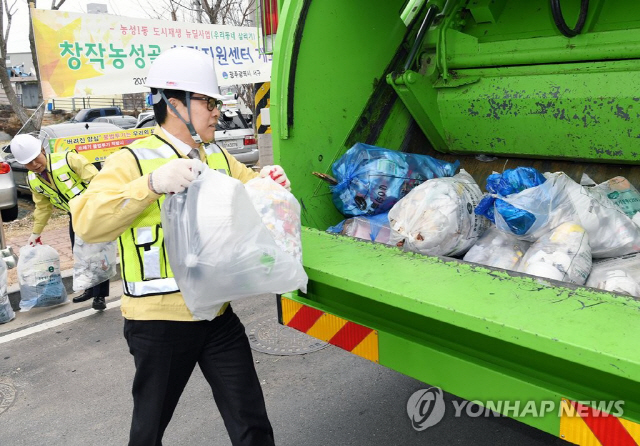 지난달 22일 오후 광주 서구청 인근 도로에서 조명래 환경부 장관이 서구에서 도입한 ‘한국형 청소차’ 운행 현장을 방문해 직접 쓰레기를 수거하고 있다.