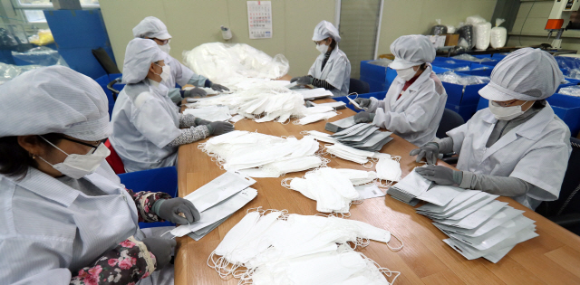 미세먼지가 연일 계속되는 6일 경남 양산시 원동면에 있는 마스크 제조업체 주식회사 엠씨에서 직원이 분주히 제품을 만들고 있다. /연합뉴스