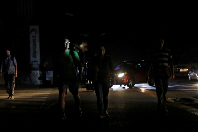베네수엘라 수도 카라카스에서 시민들이 7일(현지시간) 정전으로 어두워진 거리를 걷고 있다. /카라카스=로이터연합뉴스