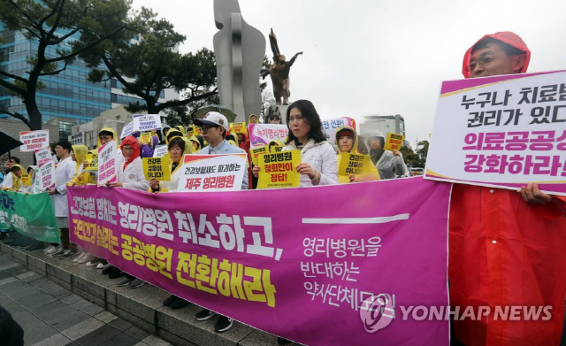 제주영리병원 반대를 위한 약사연대 모임이 10일 제주시청 앞에서 영리병원 철회와 공공병원 확충을 요구하며 집회를 열고 있다./연합뉴스