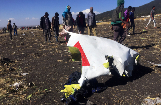 지난 10일(현지시간) 아프리카 동부 에티오피아의 비쇼프투 인근 에티오피아항공 보잉 737 맥스 여객기 추락  현장에서 구조요원 등이 여객기 잔해 옆을 수색하며 지나고 있다. /비쇼프투=로이터연합뉴스