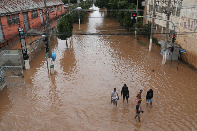 브라질 상파울루 인근 지역에서 남성들이 폭우로 물이 넘친 도로를 걷고 있다. /로이터연합뉴스
